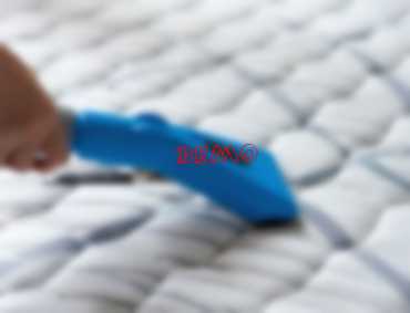 Nettoyage professionnel d'un matelas avec un aspirateur.